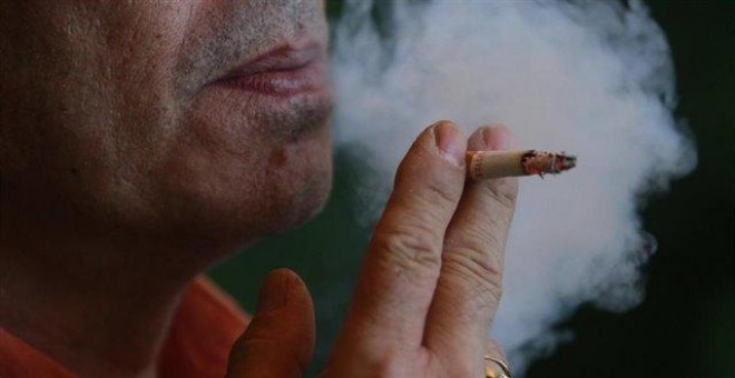 Un hombre fumando un cigarro a la vez que echa humo en una imagen de archivo / EUROPA PRESS