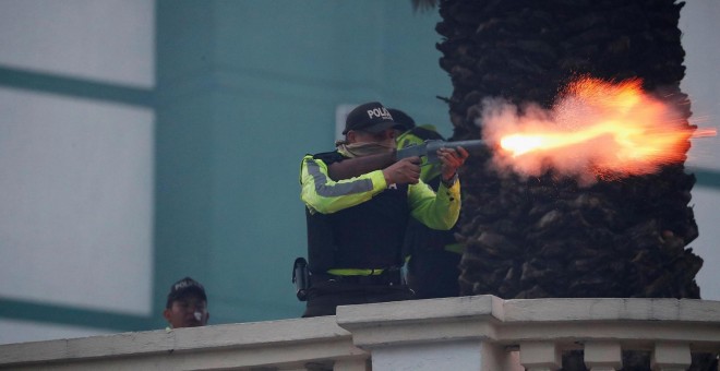 Un policía ecuatoriano dispara durante los altercados en el país. REUTERS/Carlos Garcia Rawlins