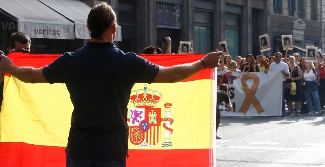 14/10/2019.- Un hombre con una bandera de España se encara con los centenares de personas que cortan la céntrica Via Laietana de Barcelona en protesta por la sentencia del 'procés'. / EFE -