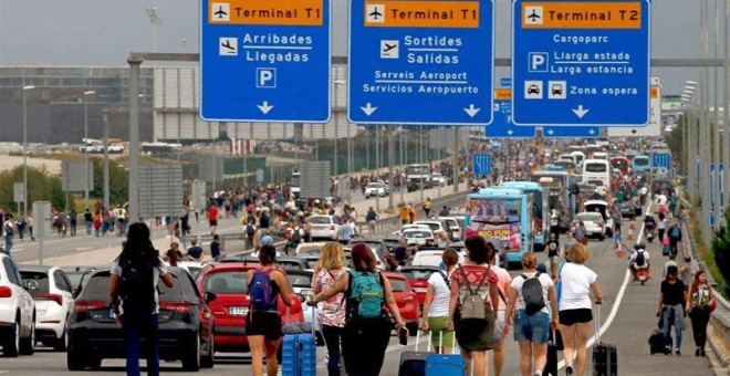 Varios viajeros llegan caminando al Aeropuerto del Prat después de que la plataforma Tsunami Democràtic haya llamado a paralizar la actividad del aeropuerto. (QUIQUE GARCÍA | EFE)