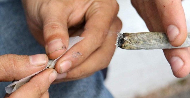 Un hombre prepara un cigarro de marihuana. EFE