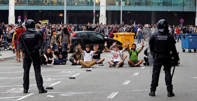 14/10/2019.- Miembros de los Mossos d'Esquadra controlan a las centenares de personas que se agolpan ante el Aeropuerto del Prat. EFE/ Toni Albir