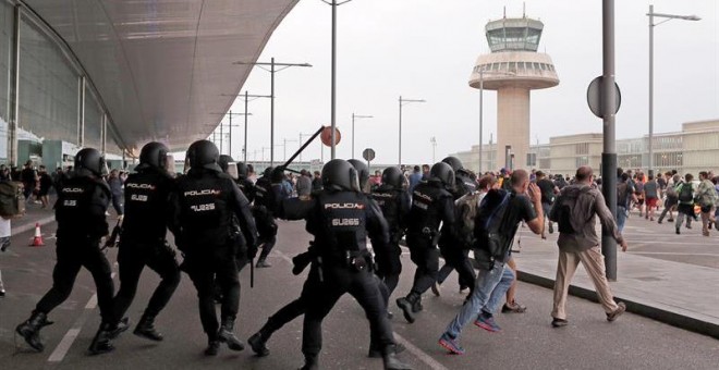 Miembros de la Policía Nacional cargan contra los centenares de personas que se agolpan ante el Aeropuerto del Prat después de que la plataforma Tsunami Democràtic haya llamado a paralizar la actividad del aeropuerto. /EFE