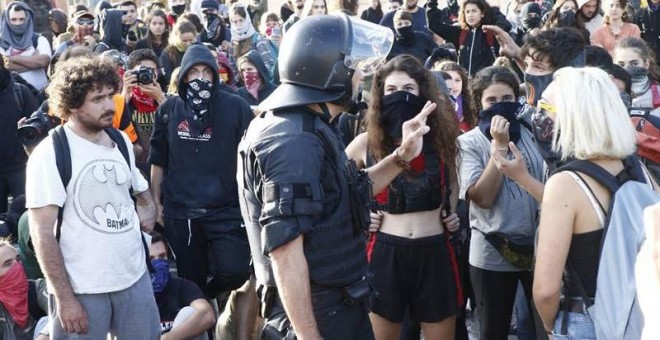 Un mosso se dirige a un grupo de estudiantes en Barcelona. (QUIQUE GARCÍA | EFE)