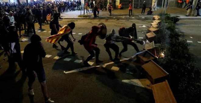 Varios manifestantes montan una barricada en el centro de Barcelona, (REUTERS)