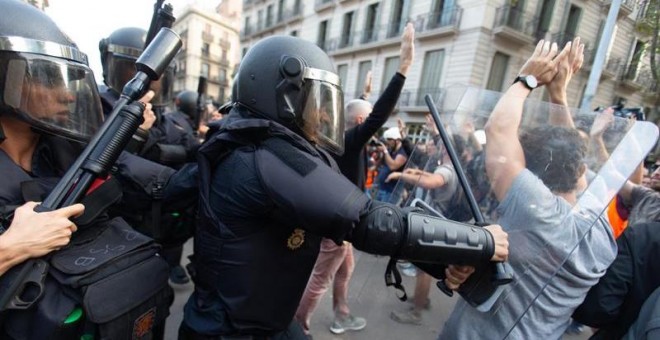 Policías dispersan a porrazos a los concentrandos en la plaza de Urquinaona de Barcelona. / EFE