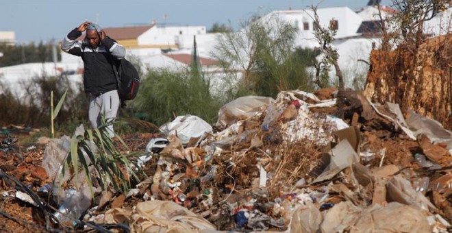 Un hombre observa el estado en el que ha quedado el asentamiento de inmigrantes en Lepe (Huelva) tras el incendio que se originó la pasada semana y que se ha arrasado con casi la totalidad del campamento, de unas cuatro hectáreas, y con 145 personas desal