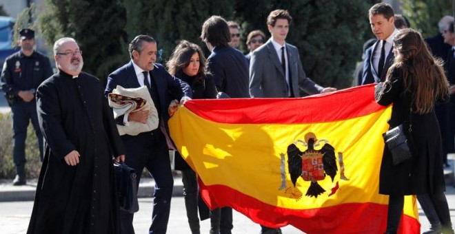 Familiares de Franco despliegan una bandera preconstitucional en el cementerio de Mingorrubio. (SUSANA VERA | REUTERS)