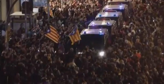 Furgones policiales se abren paso entre los manifestantes concretados en Via Laietana, en Barcelona.- CAPTURA