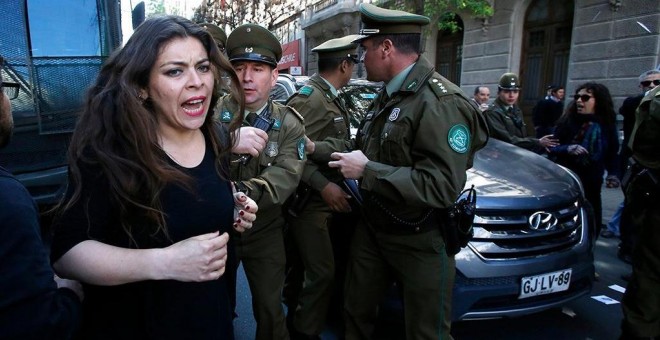 Imagen de la detención de una mujer en las protestas de Chile