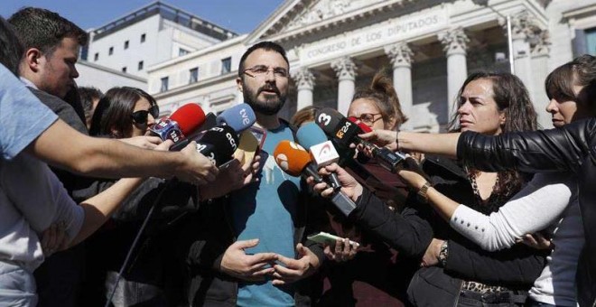 El miembro de la CUP, Albert Botran (c) atiende a los medios frente al Congreso de los Diputados durante la presentación del programa electoral de la formación catalana en Madrid. (JUAN CARLOS HIDALGO | EFE)