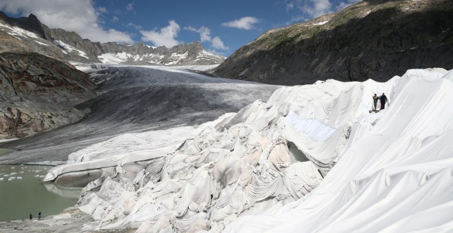 21/08/2019- Varias personas cubren la Cueva de Hielo con material para evitar que el hielo se derrita, en el Glaciar Rhone (Suiza). REUTERS / Denis Balibouse