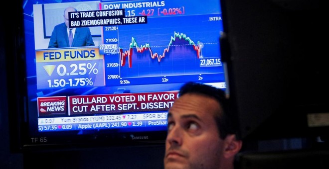 Un monitor de televisión informa de la nueva rebaja de tipos en EEUU, en el patio de negociación de la Bolsa de Nueva York, en Wall Street. REUTERS/Brendan McDermid