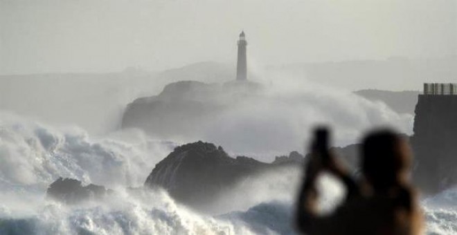 Una ola rompe en el faro de la isla de Mouro hoy domingo en la capital cántabra.EFE/Pedro Puente Hoyos
