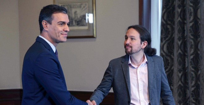 12/112019.- El presidente del Gobierno español en funciones, Pedro Sánchez y el líder de Podemos, Pablo Iglesias, se estrechan la mano en el Congreso de los Diputados donde este martes firmaron un acuerdo para la formación de un Ejecutivo. EFE/Paco Campos