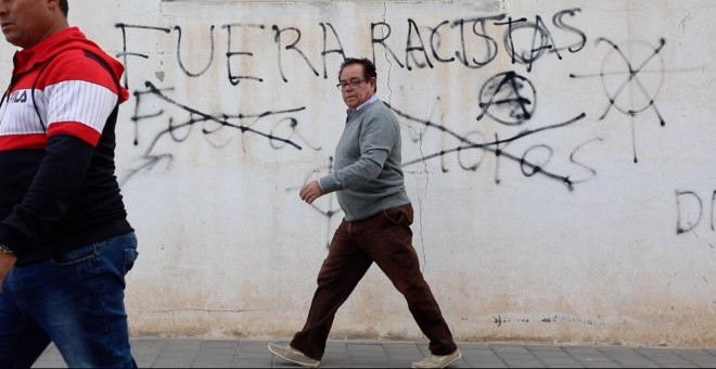 Vecinos de Torre-Pacheco (Murcia) caminan frente a unas pintadas a favor y en contra de la extremada derecha, que ha arrasado en las elecciones generales en la localidad. ENTREFRONTERAS