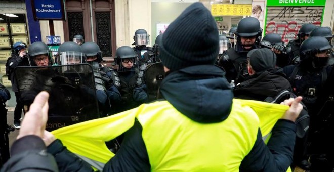 Una persona vestida con su chaleco amarillo, frente a las fuerzas policiales. EFE/CHRISTOPHE PETIT TESSON