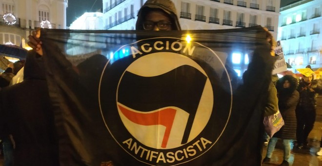 Un asistente a la manifestación porta una bandera antifascista que exhibe al final de la marcha. | Guillermo Martínez