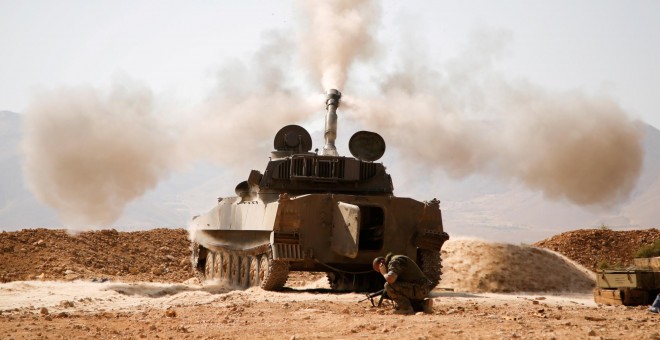 Un miembro de Hezbolá reacciona mientras dispara un arma en el oeste de Qalamoun, Siria. REUTERS / Omar Sanadiki