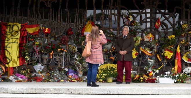 Una mujer hace una foto a un hombre en el panteón donde descansan los restos de Franco y Carmen Polo.- FERNANDO SÁNCHEZ