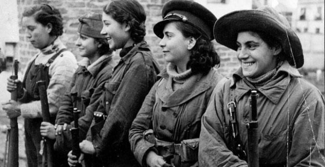 Un grupo de jóvenes mujeres forman sosteniendo unos fusiles.- MUJERES EN GUERRA