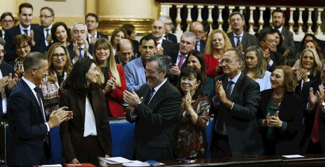 La recién elegida presidenta del Senado, la socialista Pilar Llop, entre el portavoz del PSOE, Ander Gil (i), y el anterior presidente de la Cámara Alta, Manuel Cruz, recibe el aplauso de los senadores tras su designación. EFE/ Paco Campos
