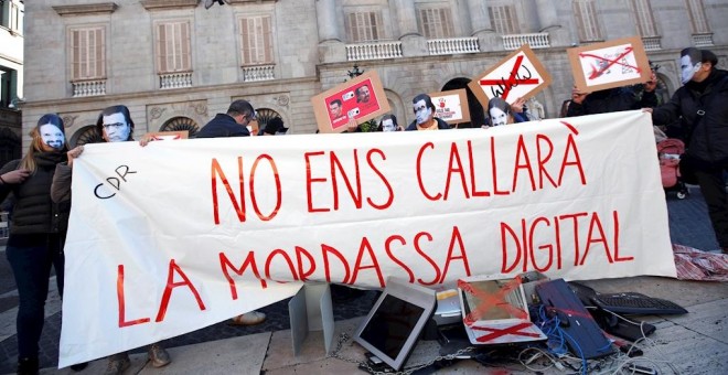 Varias personas sostienen una pancarta en la que se puede leer 'No nos callará la mordaza digital' durante una manifestación convocada por los CDR en protesta contra la Ley mordaza frente al ayuntamiento de Barcelona este sábado. EFE/Alejandro García