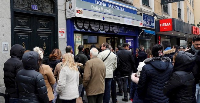 08/12/2019.- Decenas de personas hacen cola  en la administración de Loterías Doña Manolita, en Madrid, para comprar la tradicional lotería de Navidad. / EFE - BALLESTEROS