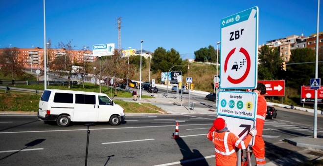 Técnicos del Ayuntamiento de Barcelona colocan la señal de la Zona de Bajas Emisiones./ Alejandro García (EFE)