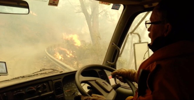 31/12/2019 - Los bomberos atraviesan las llamas durante la evacuación después de que los incendios se volvieran demasiado fuertes, Jenolan Caves, Nueva Gales del Sur, Australia. / JENOLAN CUEVAS (REUTERS)