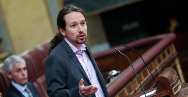 El secretario general de Podemos, Pablo Iglesias, interviene desde la tribuna del Congreso de los Diputados en la primera sesión del debate de investidura del candidato socialista a la Presidencia de Gobierno en la XIV Legislatura en Madrid (España), a 4