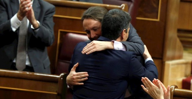 El líder de Unidas Podemos, Pablo Iglesias (i), abraza a Pedro Sánchez, tras su intervención ante el pleno del Congreso de los Diputados en la primera jornada de la sesión de investidura de Pedro Sánchez como presidente del Gobierno. EFE/Emilio Naranjo