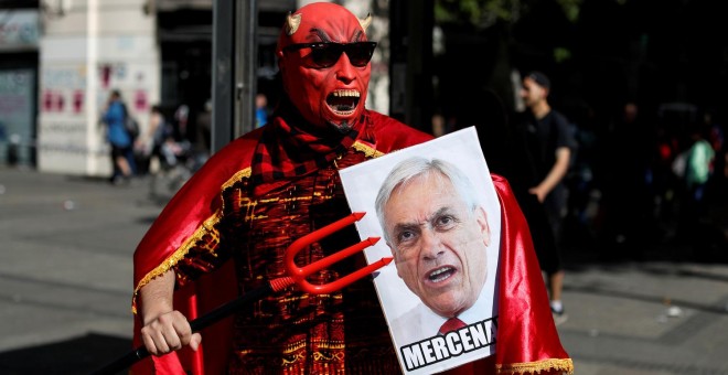 Un manifestante con una pancarta de Sebastián Piñera durante una protesta en Santiago de Chile. - REUTERS