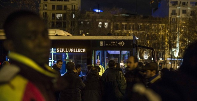 Personas sin hogar y solicitantes de asilo esperan al autobús que les llevará al albergue especial de la campaña de frío del Ayuntamiento de Madrid.- JAIRO VARGAS