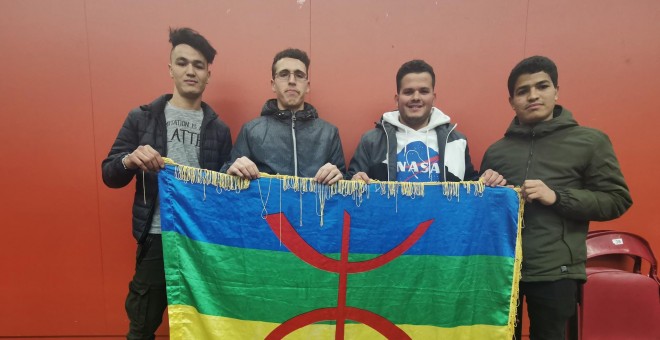 Unos jóvenes sostienen una bandera con los colores amazighs. QUERALT CASTILLO.