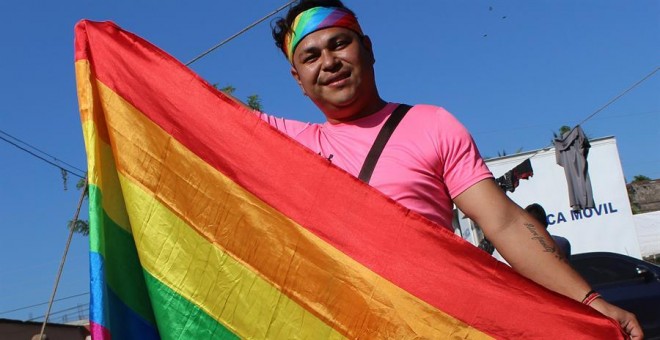 Mavisa, una mujer transexual que viaja en la caravana de migrantes hondureños, posa con la bandera de arcoíris | EFE