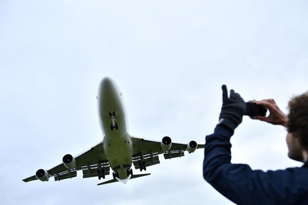 Un hombre fotografía con su teléfono a un avión. (REUTERS/Dylan Martínez)
