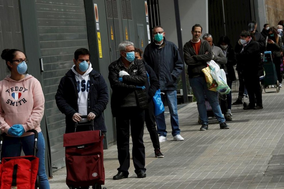 Varios clientes guardan cola para entrar en un supermercado de la Gran Via de Barcelona, este miércoles, cuando se cumple el undécimo día del estado de alarma decretado por el Gobierno por la pandemia de coronavirus. EFE/Toni Albir