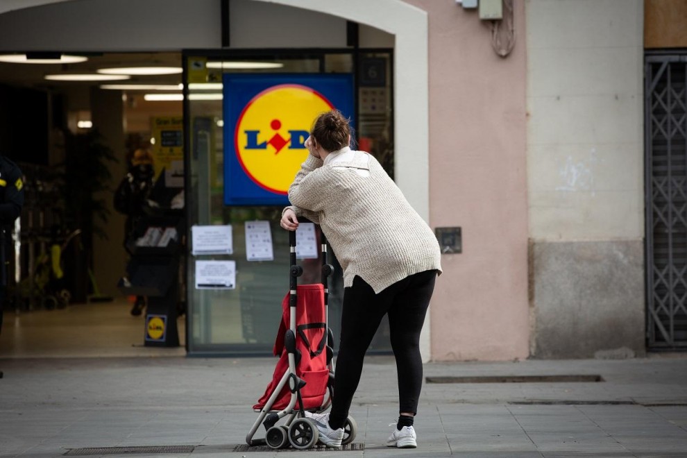 Una mujer espera con su carro de la compra a poder entrar a un supermercado Lidl , en Barcelona. E.P./David Zorrakino