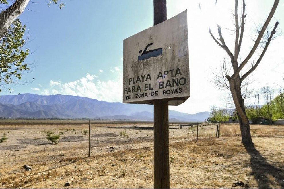 "Playa apta para el baño", reza un cartel de un lago chileno desaparecido por la sequía. AFP/Martín Bernetti