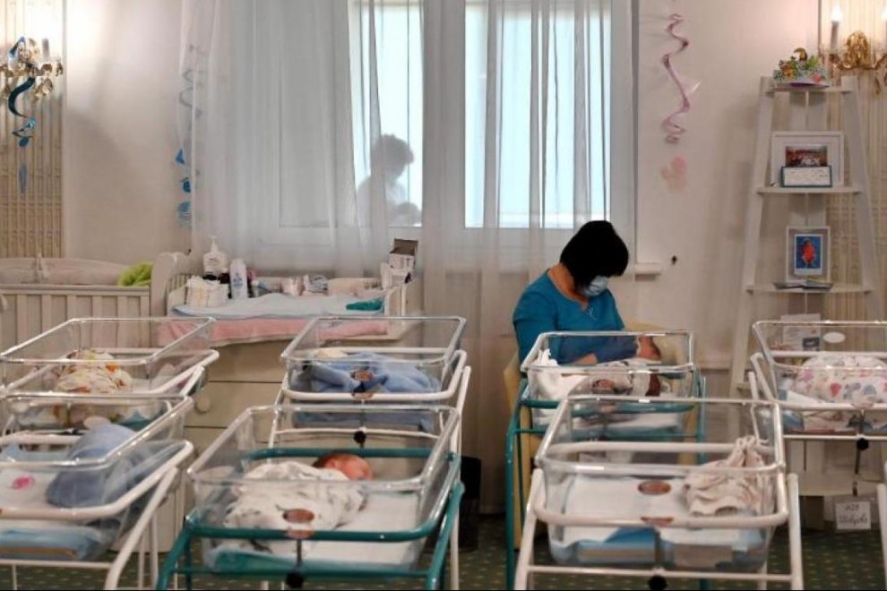 Una enfermera cuida de un recién nacido por gestación subrogada en el hotel Venice de Kiev.- AFP