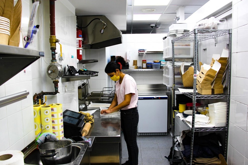 Una socia de una 'cocina fantasma' prepara una comida en su lugar de trabajo.