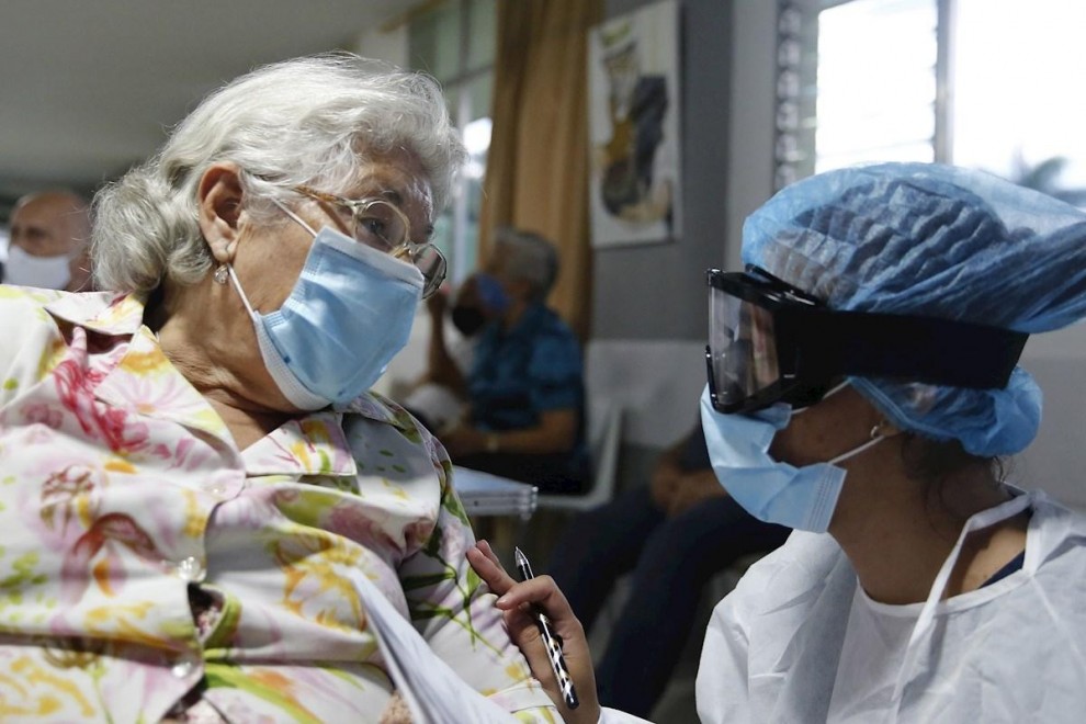 Una sanitaria conversa con una mujer antes de aplicarle la vacuna contra la covid en Medellín, Colombia.
