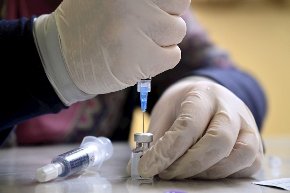 Imagen de archivo de un sanitario preparando una dosis de una vacuna contra la covid.