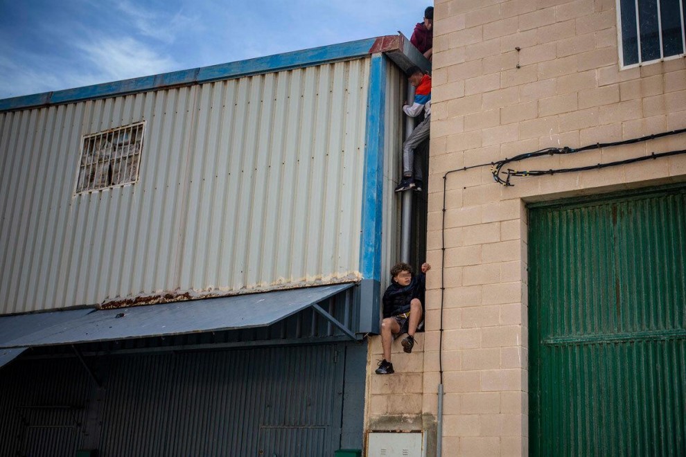 Tres niños marroquíes llegados a Ceuta durante los últimos días escapan de la nave del Tarajal donde llevan días hacinados por falta de otros espacios.