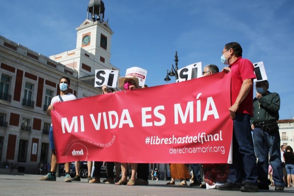 Un grupo de personas se reúne sosteniendo pancartas y carteles durante la concentración de la asociación Derecho a Morir Dignamente (DMD) en la Puerta del Sol, a 25 de junio de 2021, en Madrid, (España)