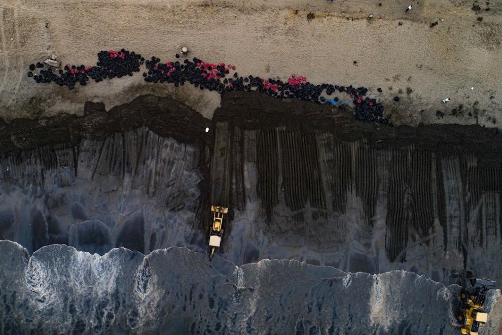 Fotografía aérea tomada desde un dron que muestra una vista general de las operaciones de limpieza de crudo en el mar de Ventanilla, en Perú.