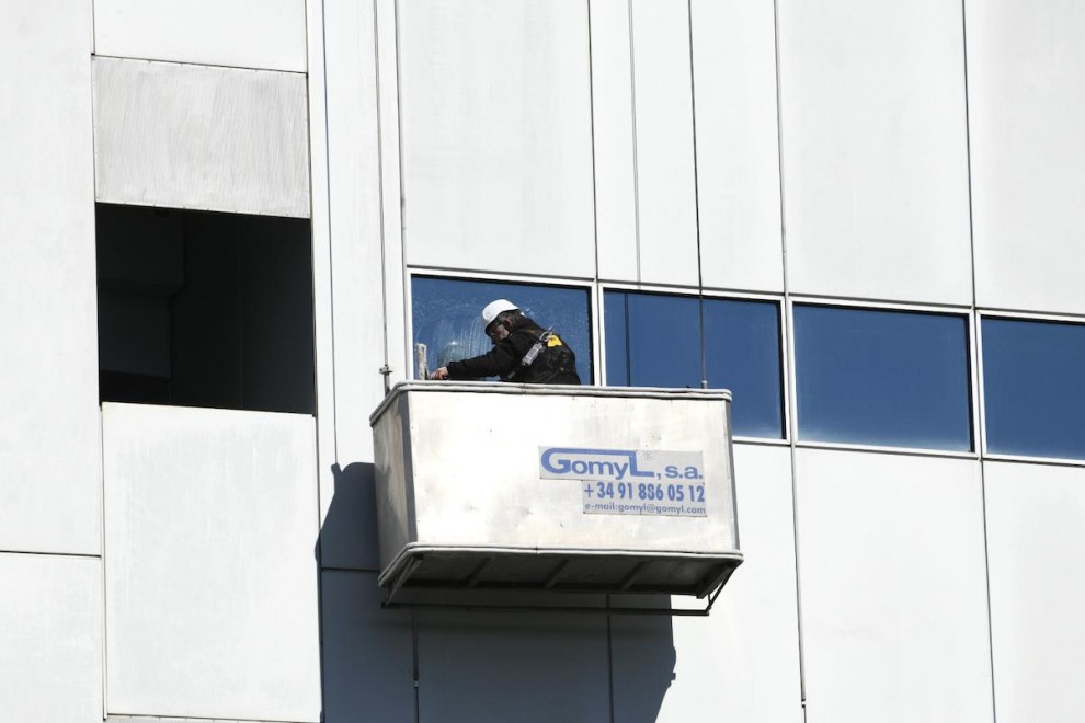 Un trabajador limpia los cristales de un edificio, en Madrid, a 21 de febrero de 2020.