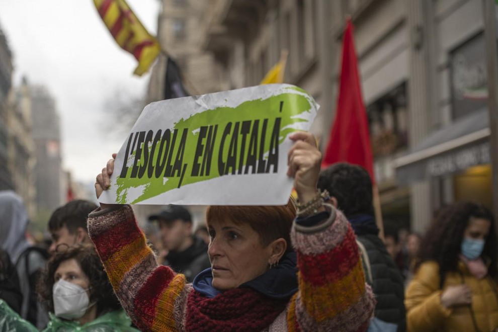 Una manifestante con una pancarta que reza 'L'escola, en catalá', en una huelga por la sentencia del 25% en castellano en la educación catalana, a 23 de marzo de 2022, en Barcelona.