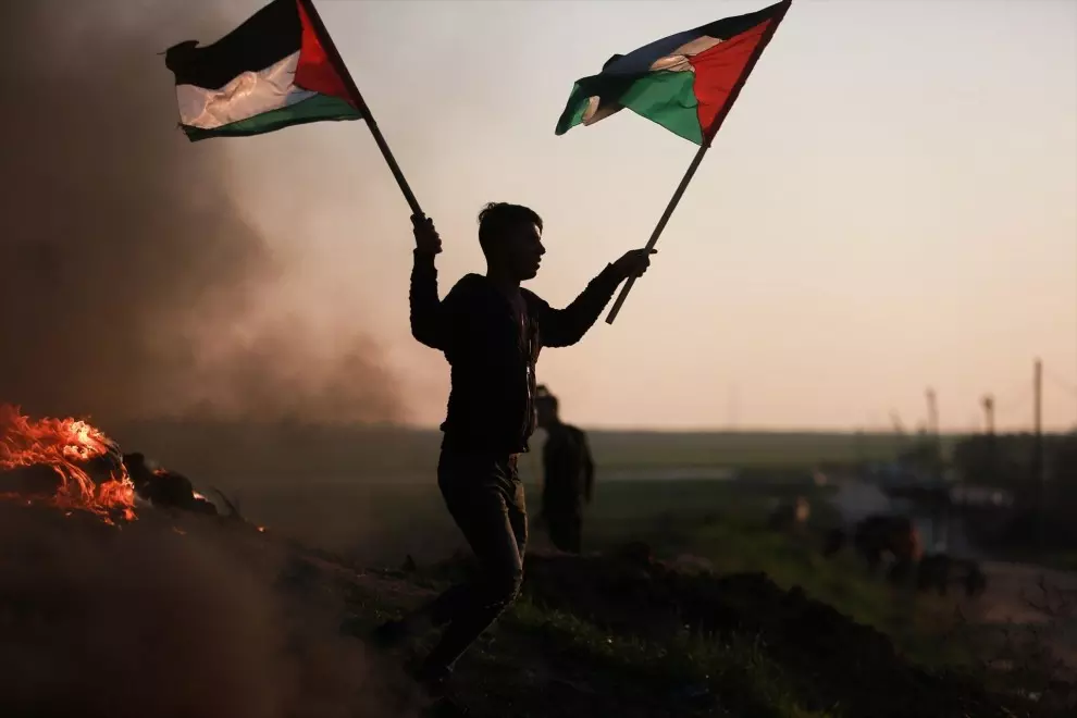 Un manifestante con la bandera de Palestina en la frontera de Gaza protesta tras los últimos ataques contra un campamento de refugiados en Yenín.